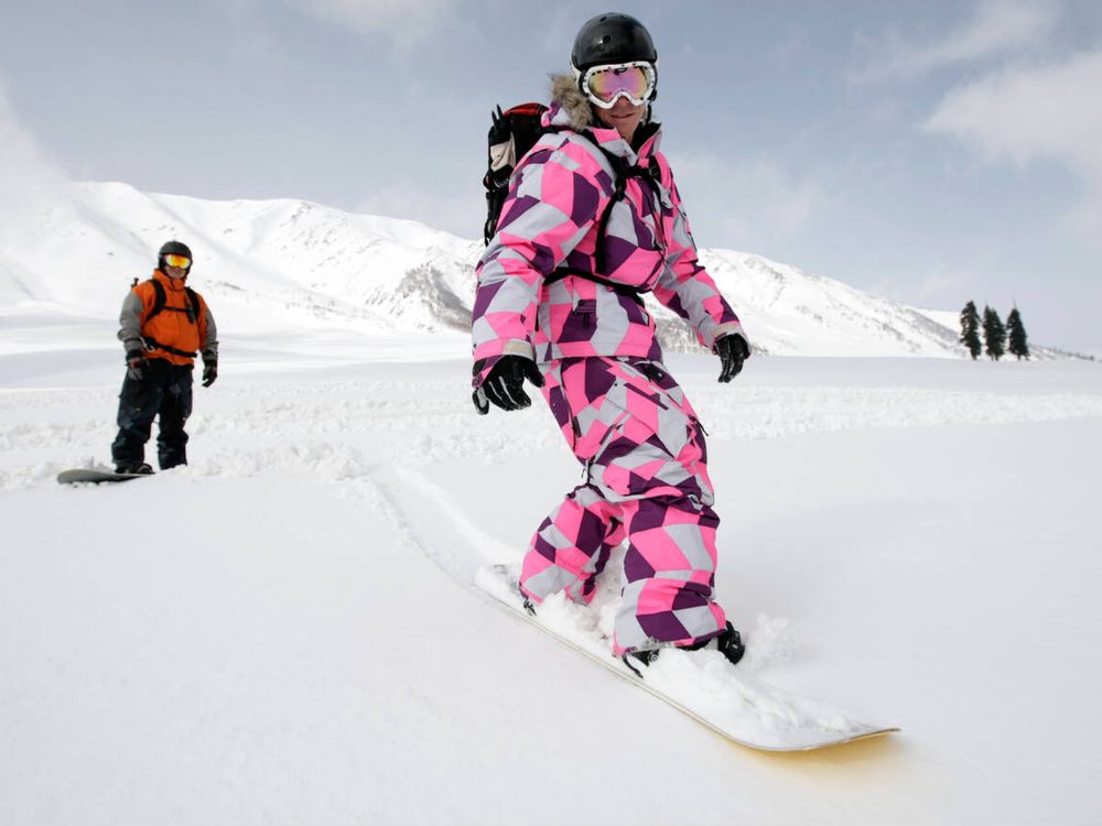 Snowboarders enjoy a run at Gulmarg ski fields Kashmir India