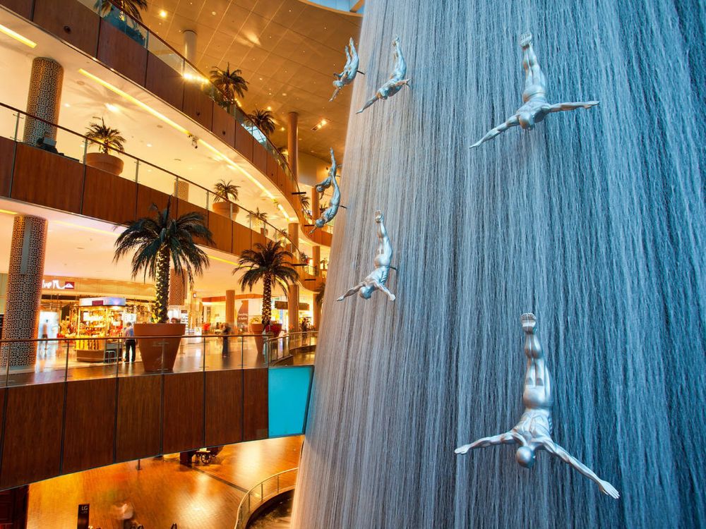 Dubai, waterfall and sculptures of diving men inside Dubai Mall