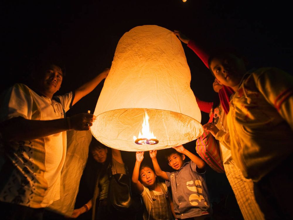 A Thai family light a khom loi (sky lantern) during the Naga Fireballs festival in Phon Phisai