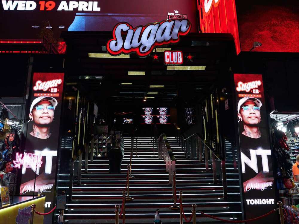 Nighttime view of Sugar Club in Phuket with glowing signage.