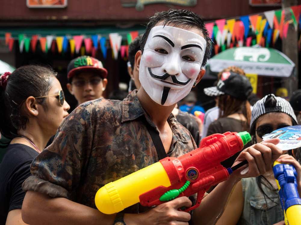 Masked-man holding water gun during the Songkran festival in Thailand