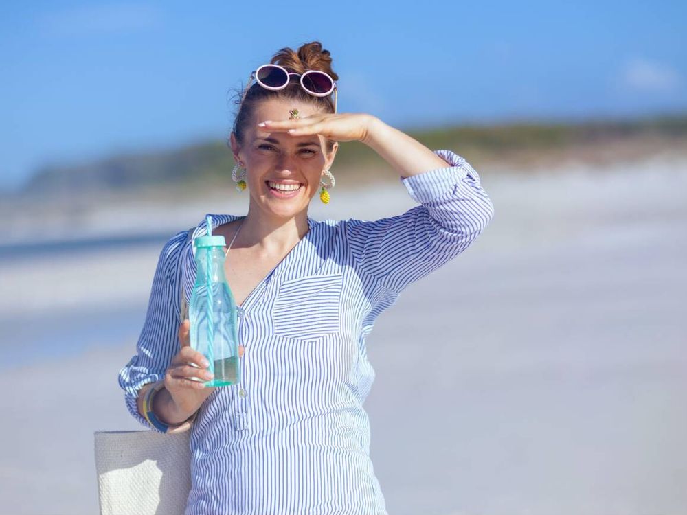 A woman posing for camera holding a water bottle in the Maldives
