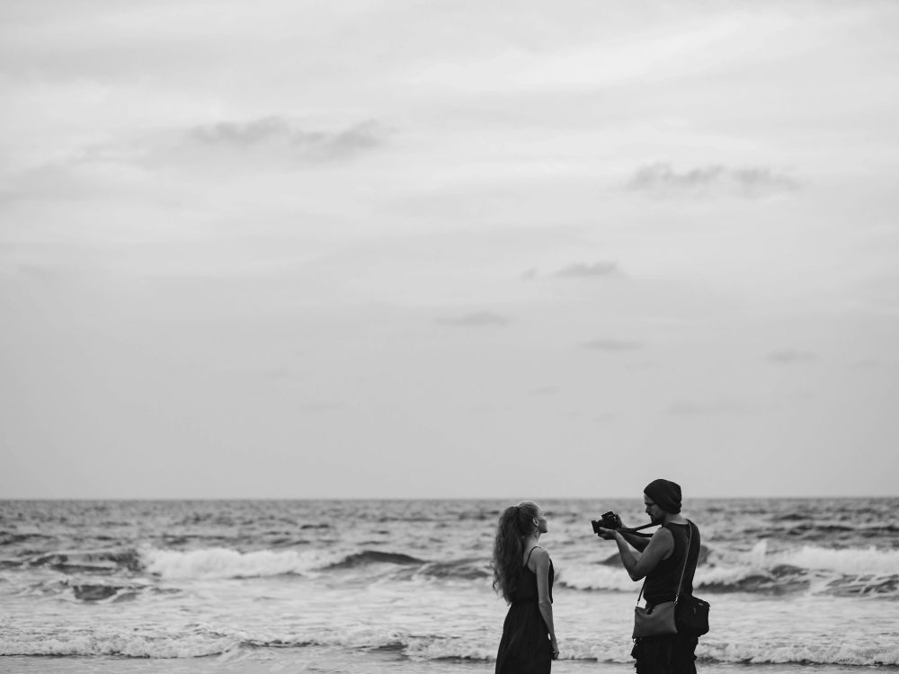 A couple doing photography on a quiet beach in Goa