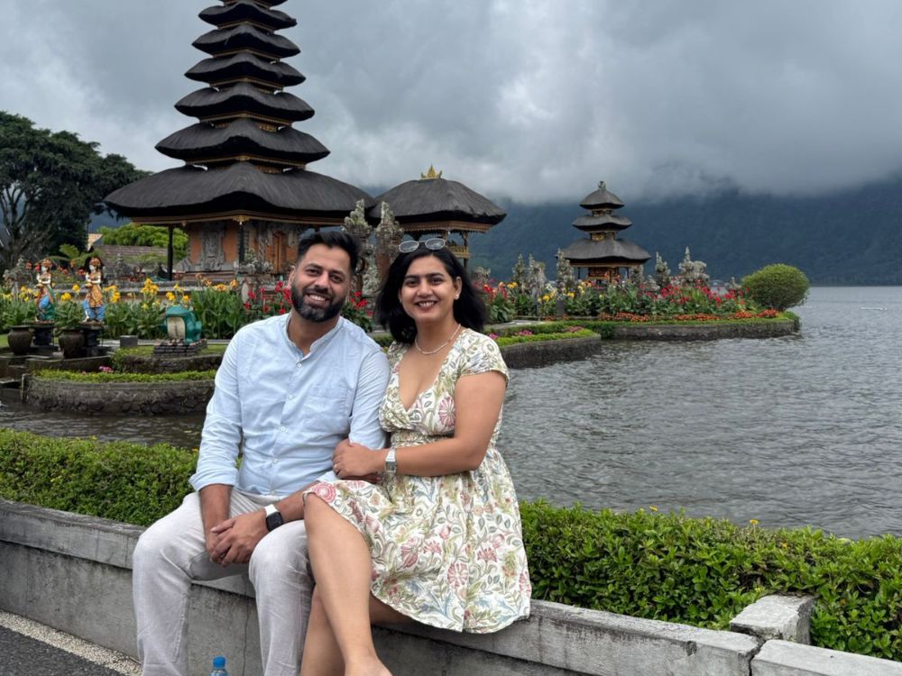 Couple sitting in front of Uluwatu temple in Bali.