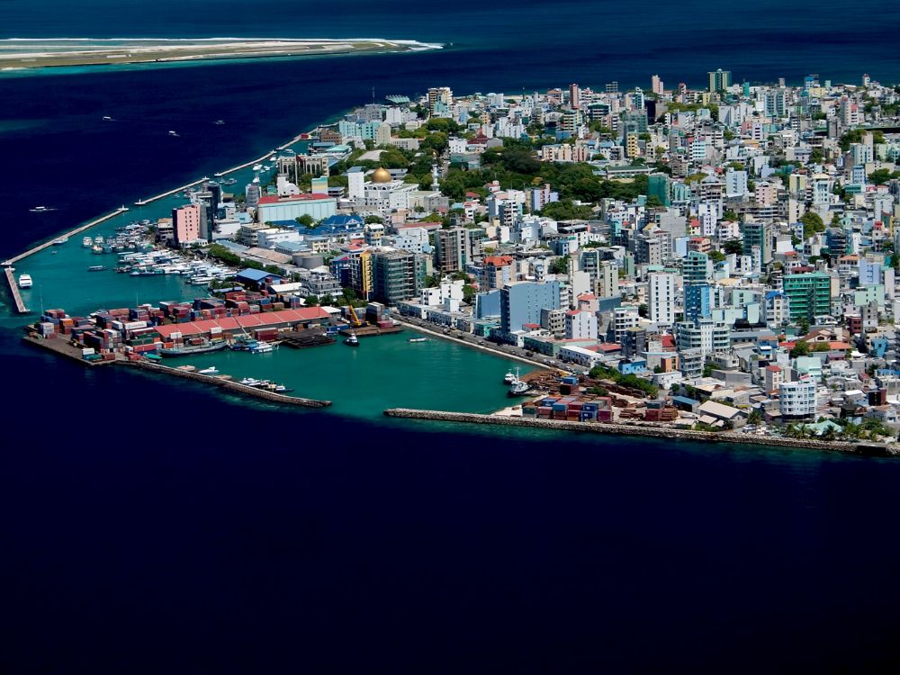 An aerial, high-angle photograph showing the entire island city of Malé in the Maldives.